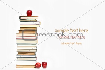 Pile of books and apples on white