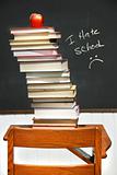 Stack of books on an old school desk 