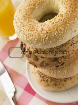 Stack of Seeded Bagels with a Glass of Orange Juice