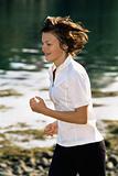 Young woman running along water's edge