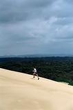 Man running up sand dune