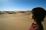 Young woman looking across sand dunes