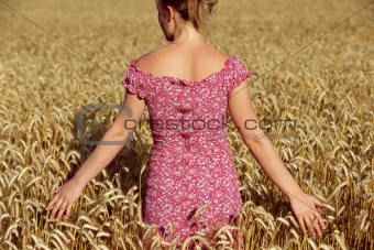 Rear view of young woman standing in wheatfield