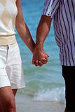 Couple walking on beach holding hands