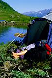 Young woman asleep in tent next to lake, 