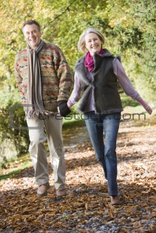 Senior couple walking through autumn woods