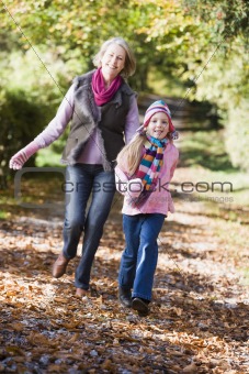 Grandmother and granddaughter playing in woods