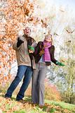 Young couple having fun with autumn leaves