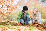 Two children collecting leaves