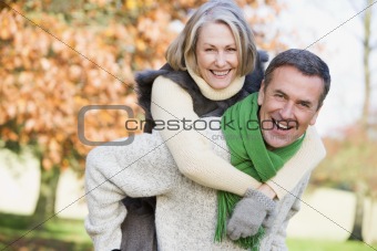 Senior man giving woman piggyback ride