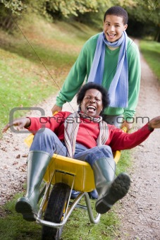 Son pushing mother in wheelbarrow