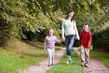 Mother and children walking along woodland path