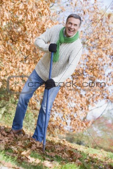 Senior man tidying leaves in garden