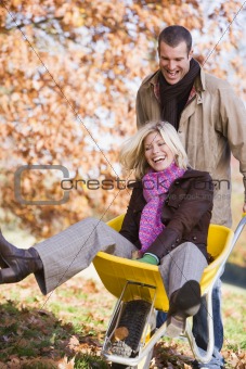 Man pushing woman in wheelbarrow