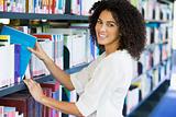 Woman pulling a library book off shelf