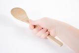 Hand holding wood spoon