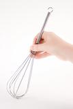 Hand holding a whisk