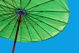Bright green umbrella against a blue sky