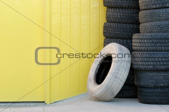 stack of tires against yellow wall