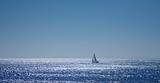 calm ocean and sailing boat in the distance