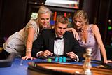 Man with glamorous women in casino