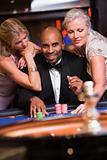 Man in casino with glamorous women