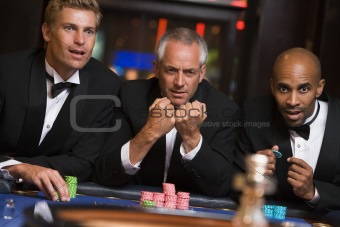 Group of male friends gambling at roulette table