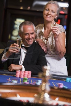 Couple gambling at roulette table