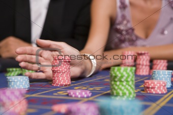 Close up of woman placing bet on roulette table