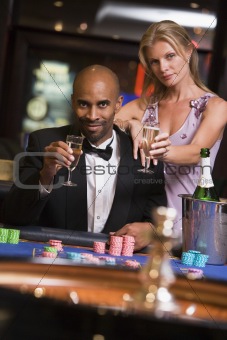 Couple gambling at roulette table