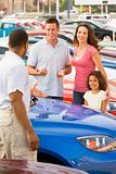 Family discussing new car with salesman 