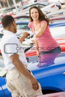 Woman picking up keys to new car