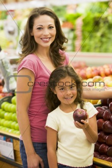 Mother and daughter buying fresh fruit