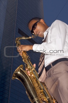 Urban saxophone player on skyscraper background