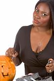 Black make-up artist decorating Halloween pumpkin