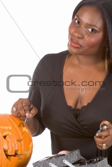 Black make-up artist decorating Halloween pumpkin