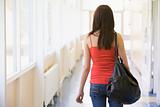 Rear view of female college student in university corridor
