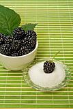 Blackberries in a bowl and sugar