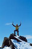 Young man celebrating reaching the top of a mountain