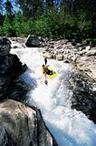 Young man kayaking in rapids