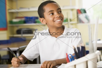 A schoolboy studying in class