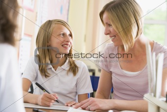 A schoolgirl sitting with her teacher in class