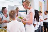 Teacher holding plate of lunch in school cafeteria