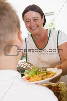 Lunchlady serving plate of lunch in school cafeteria
