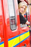 Female firefighter sitting in the cab of a fire engine