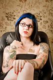 Pretty Woman with Tattoos in a Leather Chair