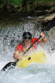 Young man kayaking in river