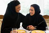 Two Middle Eastern women enjoying a meal in a restaurant