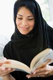 A middle eastern woman reading a book