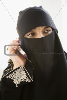 A middle eastern woman talking on a cellphone